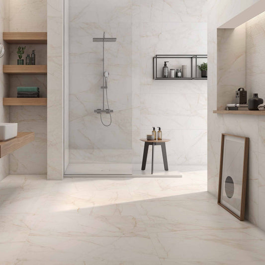 Casa de banho ampla com o cerâmico Marble Dolomita Blanco Polido aplicado no pavimento e na zona do duche, contrastando com uma parede texturada em tom cobre.