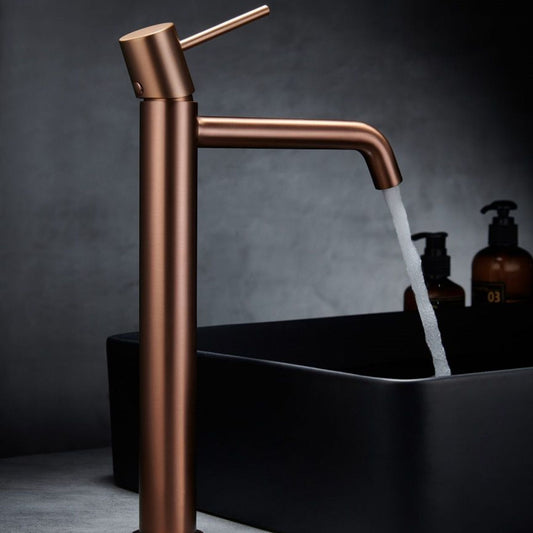 Torneira de lavatório monocomando Monza alta Ouro Rosa Mate em uso, com água a correr para lavatório de bancada preto