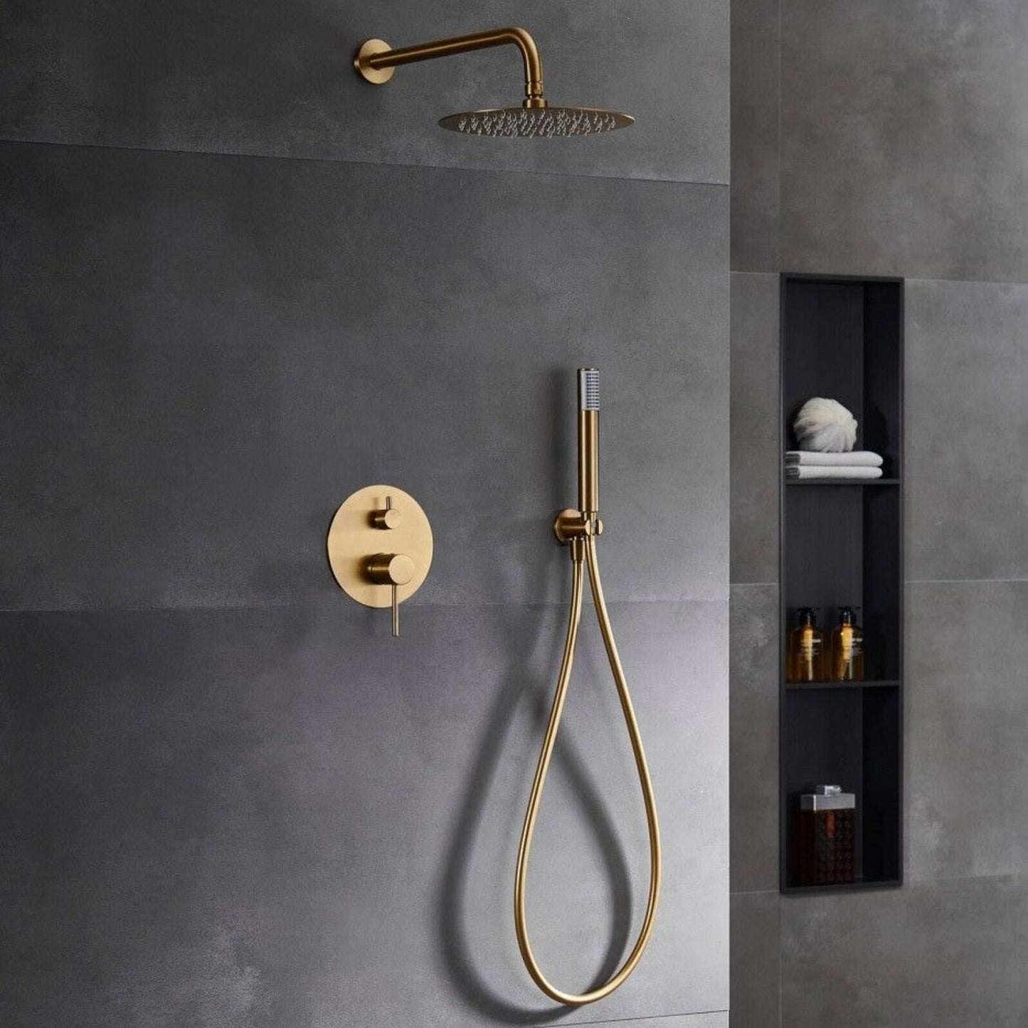 Sistema de duche Monza ouro mate instalado em parede de casa de banho moderna em tons de cinza.