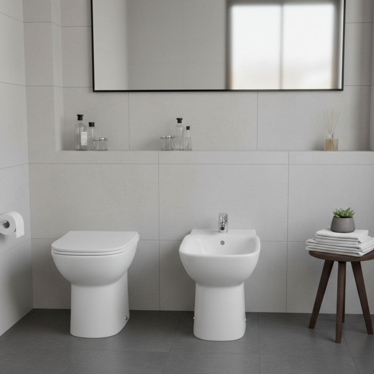 Ambiente de casa de banho com bidé e sanita de pousar da série Polo da Roca, destacando o design clássico com pé.