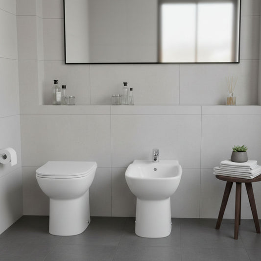 Ambiente de casa de banho com bidé e sanita de pousar da série Polo da Roca, destacando o design clássico com pé.