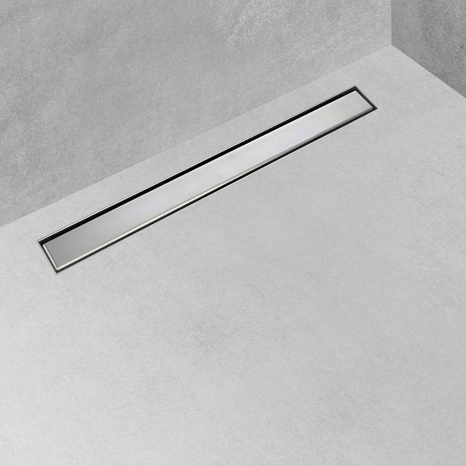 Calha de duche com grelha plana instalada num pavimento de casa de banho em microcimento cinza.