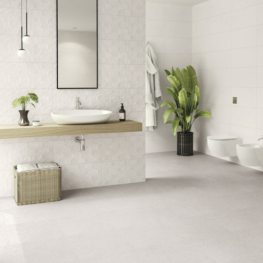 Alt Text: Casa de banho moderna, com paredes parcialmente revestidas com o decorado Eternal Stone Talisman White e peças sanitárias brancas.