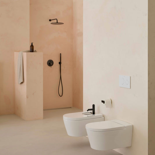 Ambiente de casa de banho de luxo com conjunto suspenso de sanita e bidé da gama Inspira Round da Roca.