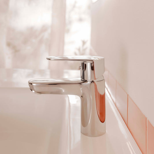 Vista lateral da torneira Roca VICTORIA PLUS cromada instalada em lavatório branco