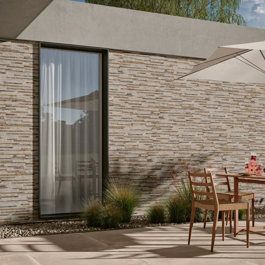 Alt Text: 'Exterior de casa com fachada revestida com o revestimento Linea Multicolor, destacando-se numa área de lazer com móveis de exterior.'
