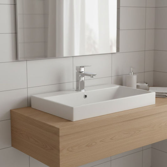 Torneira Grohe Cubeo cromada instalada num lavatório de pousar branco sobre bancada de madeira em ambiente de casa de banho moderna.