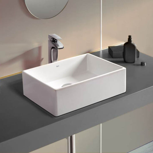 Lavatório de bancada Roca Sofia 46 cm branco em ambiente de casa de banho, com torneira de bancada alta.