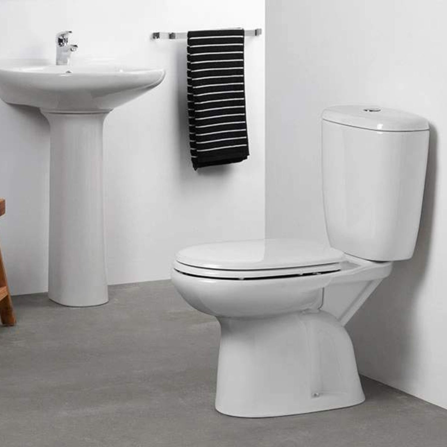 Pack sanita Sanindusa Luxor branco instalado numa casa de banho moderna, ao lado de um lavatório com pedestal branco.