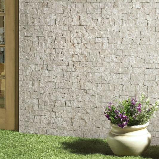 Parede decorativa de jardim interior com revestimento Pedra Nacar e vasos de flores.