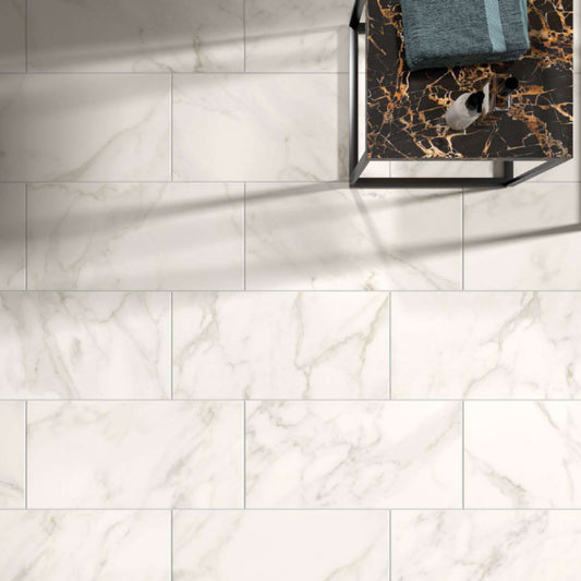 Pavimento cerâmico Bernini Calacatta Oro aplicado em sala com decoração moderna e veios dourados visíveis.