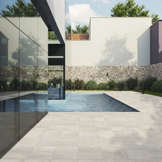 Área exterior de moradia e piscina pavimentada com cerâmica Certeca Hard Stone Sand 33x33cm.
