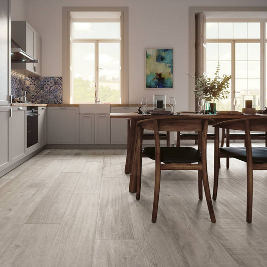 Cozinha e zona de refeição com pavimento cerâmico Gresart Vermont Ash 25x150cm no chão.