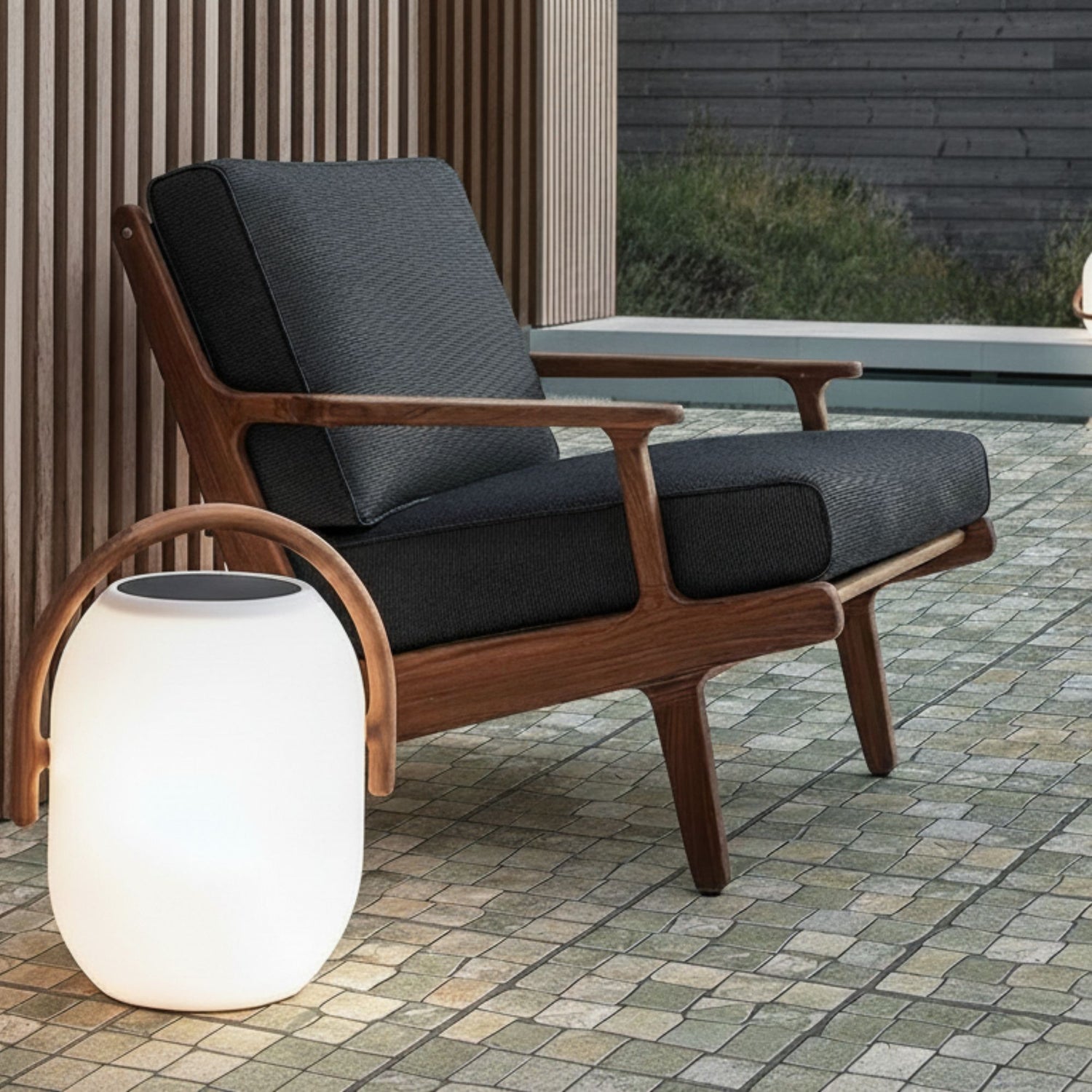 Pavimento Nazaré Cotto aplicado em pátio exterior com mobiliário de jardim e iluminação decorativa.