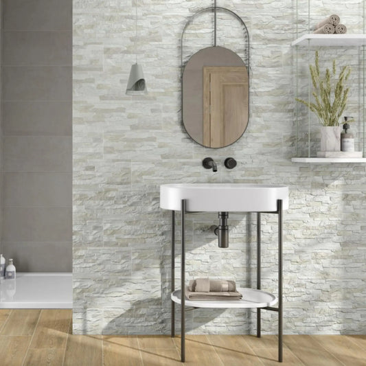 alt text= 'Revestimento cerâmico Titan Neutro 17x52 cm aplicado na parede de uma casa de banho, com design que imita pedra natural empilhada'