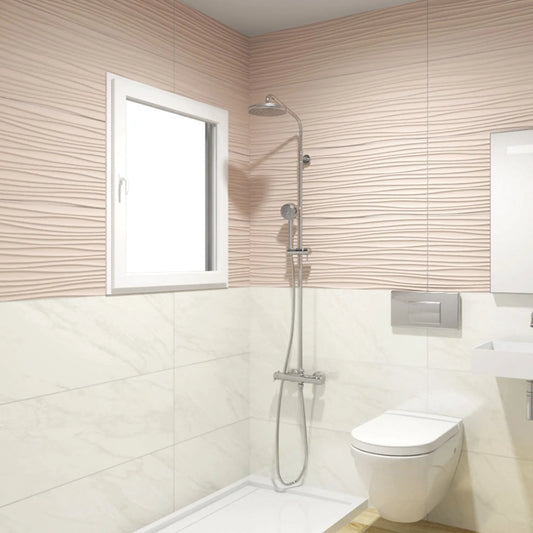 alt='Pavimento cerâmico Marble White aplicado na parede inferior de uma casa de banho moderna, junto a um duche e sanita.'