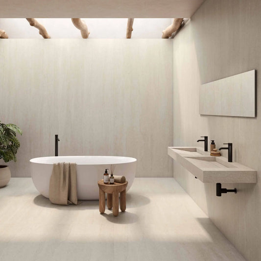 Alt Text= 'Casa de banho luxuosa com o cerâmico Serena Veincut Bone aplicado no pavimento e nas paredes, com uma banheira oval branca.'