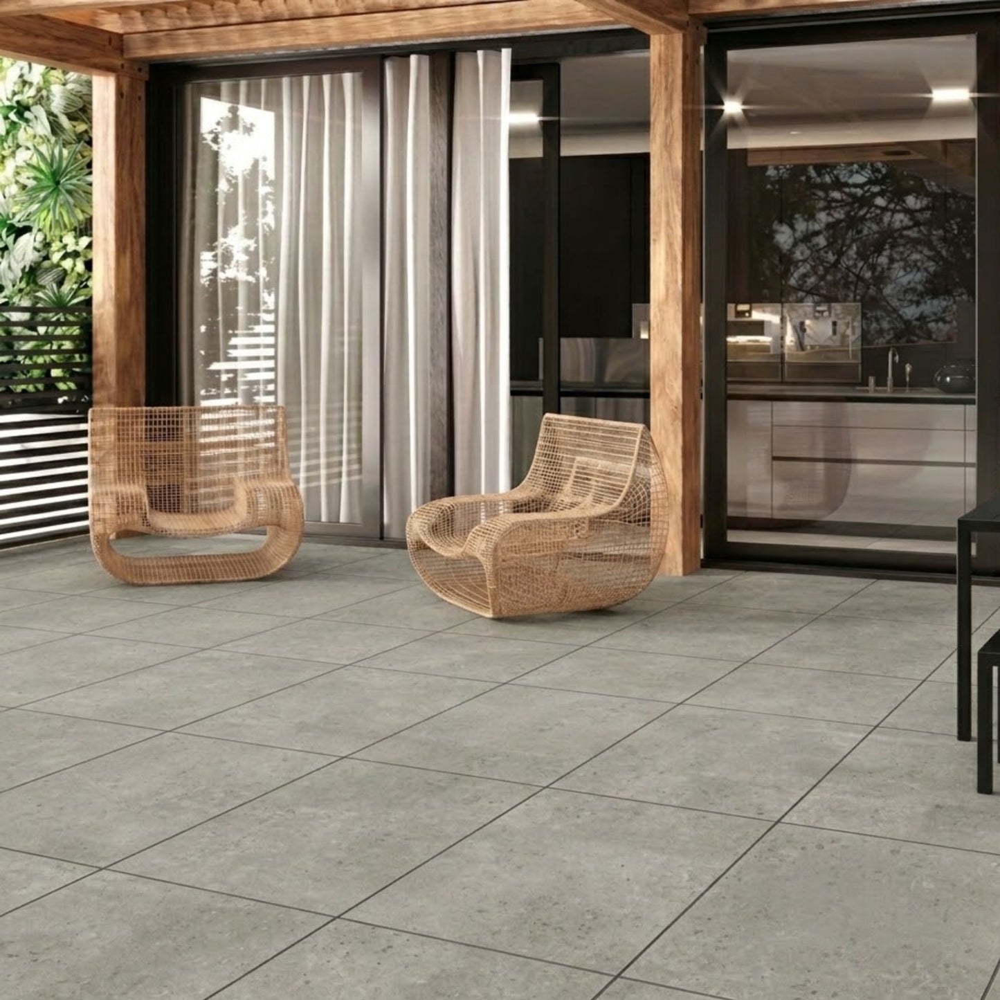 Terraço exterior decorado com pavimento cerâmico Pamesa Eaton Coal e mobiliário de jardim.