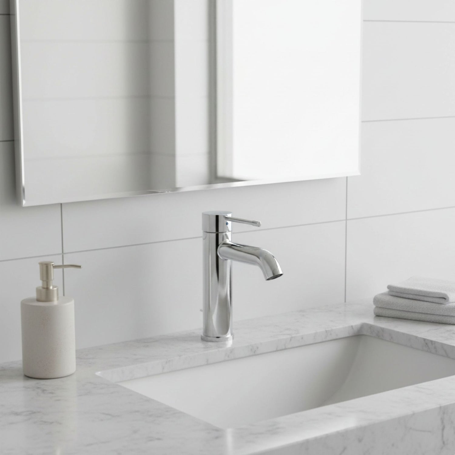 Torneira Grohe Essence S cromada instalada num lavatório de mármore branco em ambiente de casa de banho moderna.