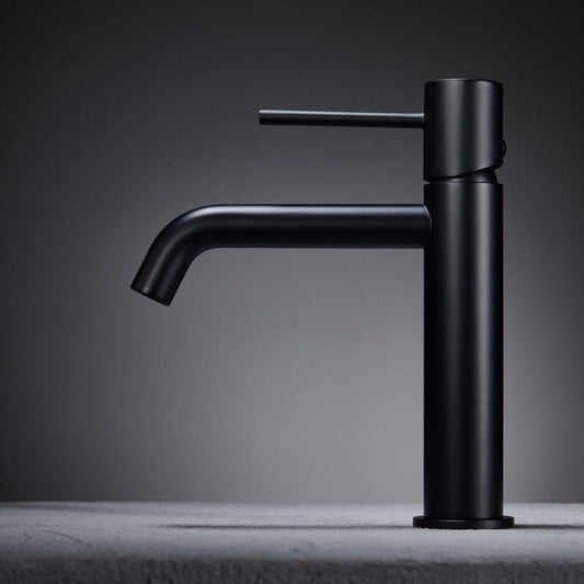 Torneira de lavatório Monza preto mate com design moderno, pousada numa bancada cinza.